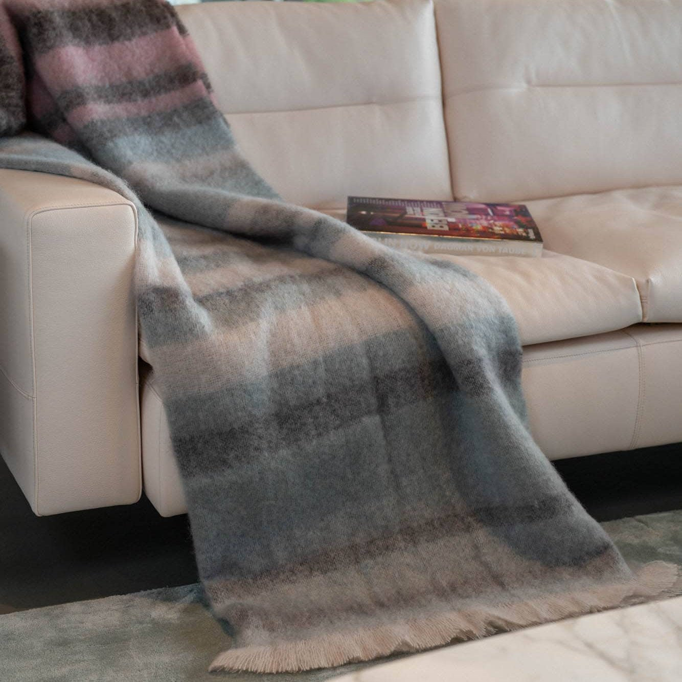 Charterhouse Mohair Plaid in braun, rosa, blaugrau gestreift auf dem Sofa