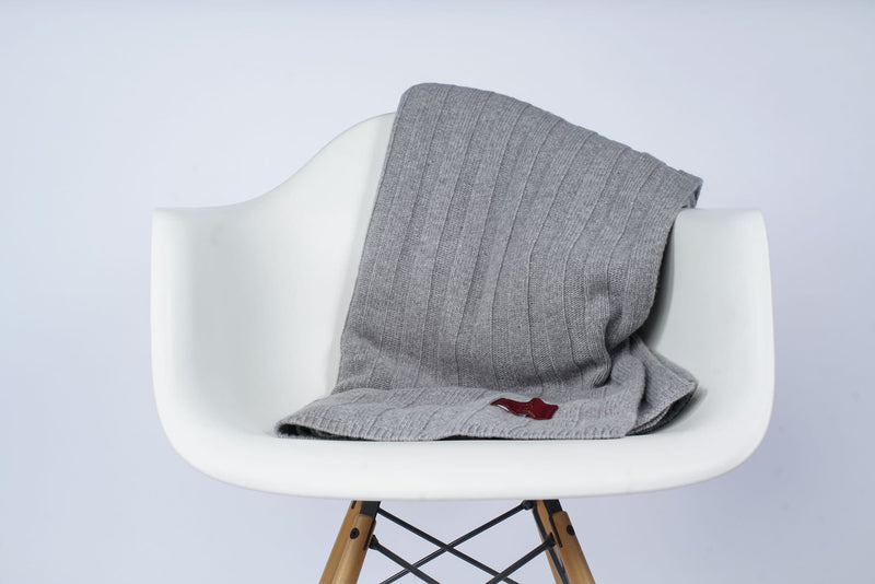Gefaltetes Estoril Strickplaid in grau auf dem Stuhl
