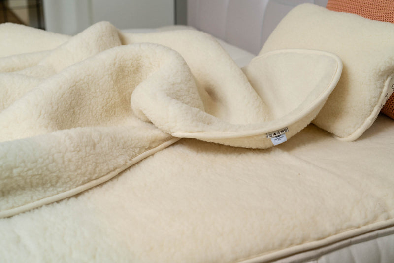 Flokati Luka Wollflor Bettdecke in naturweiß auf dem Bett