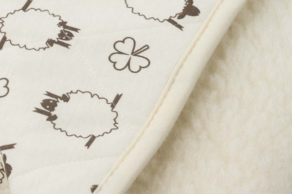 Alpin Kinder Wollflor Bettdecke in naturweiß mit Schaf- und Kleeblattmuster im Detail
