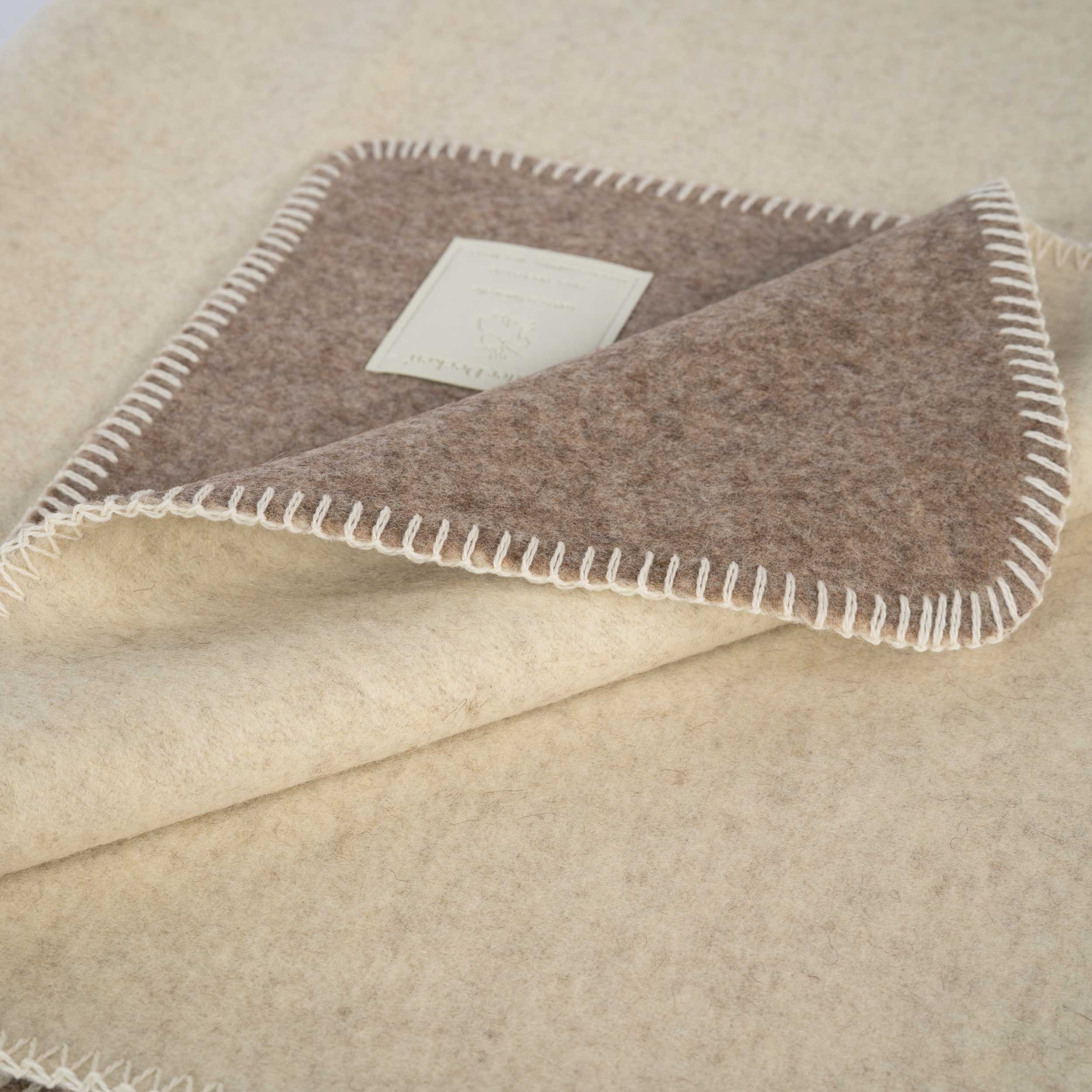 Lilienthal Schurwolldecke in natur-/graumeliert auf der Bank