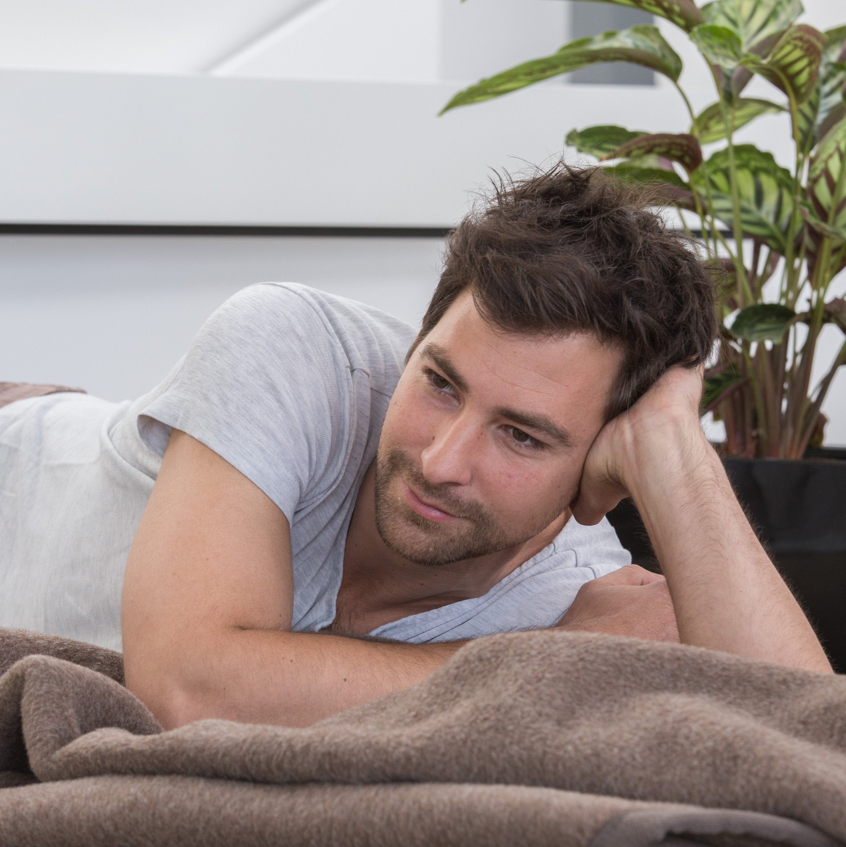 Model liegt mit Perulama Alpakadecke in dunkelbraun meliert