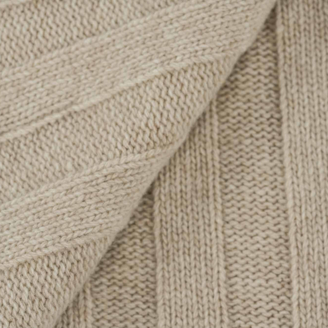 Gefaltetes Estoril Strickplaid in creme im Detail Strickdecke aus Schurwolle
