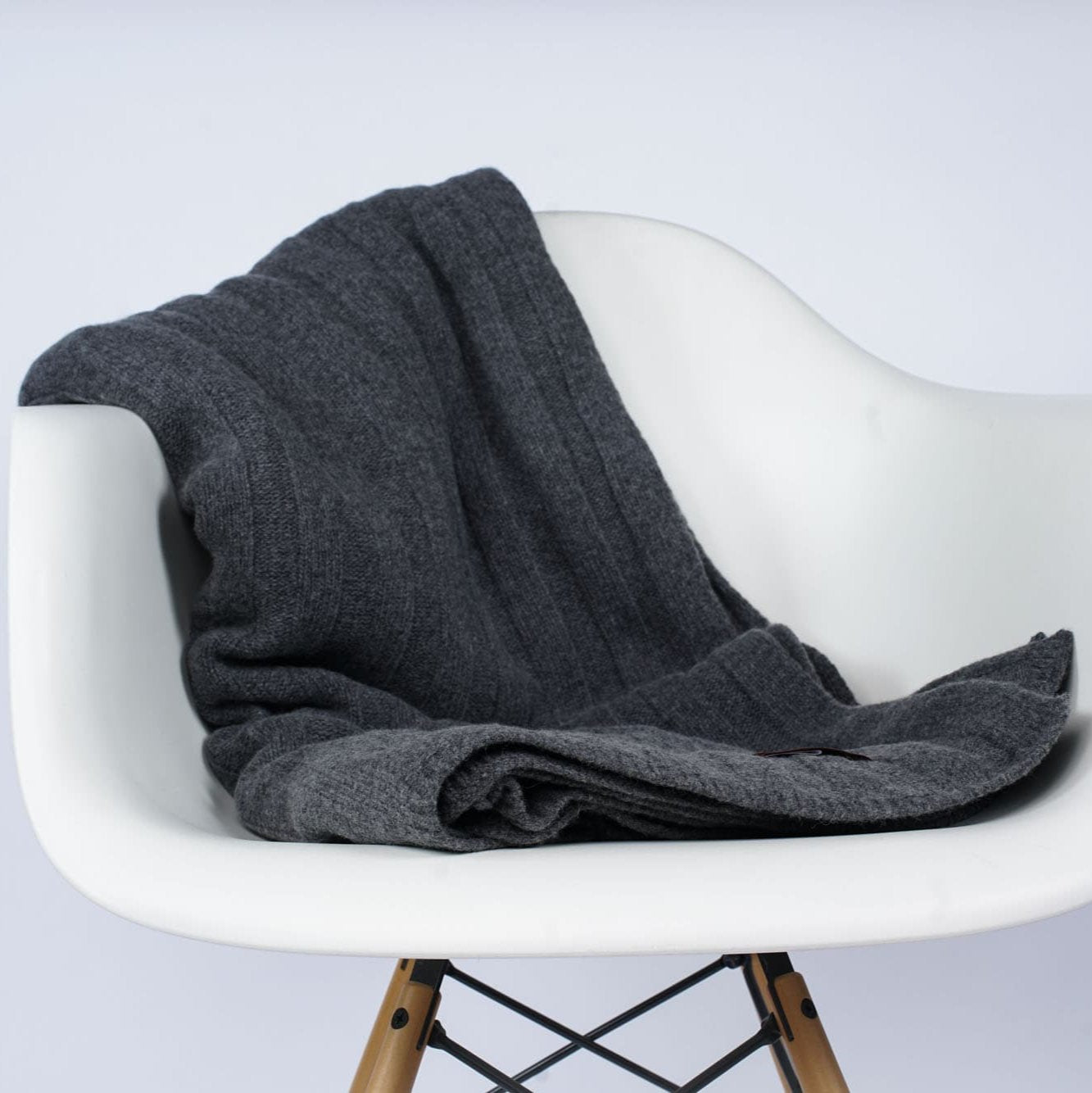 Gefaltetes Estoril Strickplaid in anthrazit auf dem Stuhl