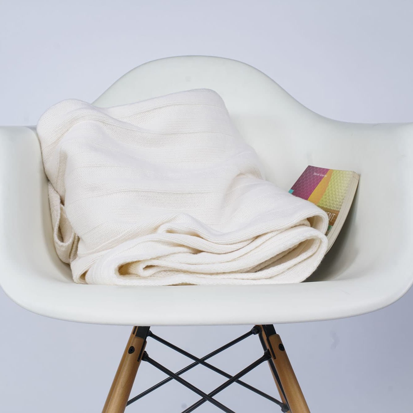 Gefaltetes Estoril Strickplaid in weiß auf dem Stuhl