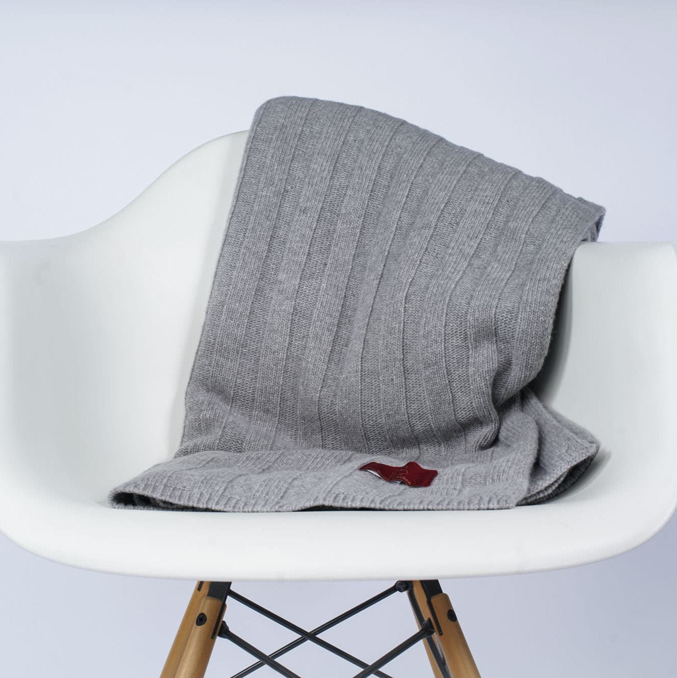 Gefaltetes Estoril Strickplaid in grau auf dem Stuhl