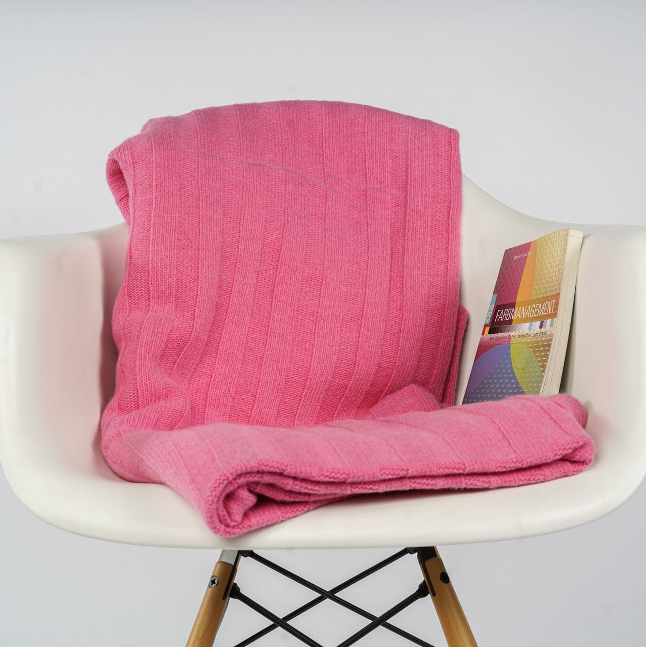 Gefaltetes Estoril Strickplaid in pink auf dem Stuhl