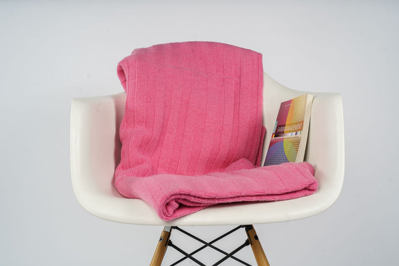 Gefaltetes Estoril Strickplaid in pink auf dem Stuhl