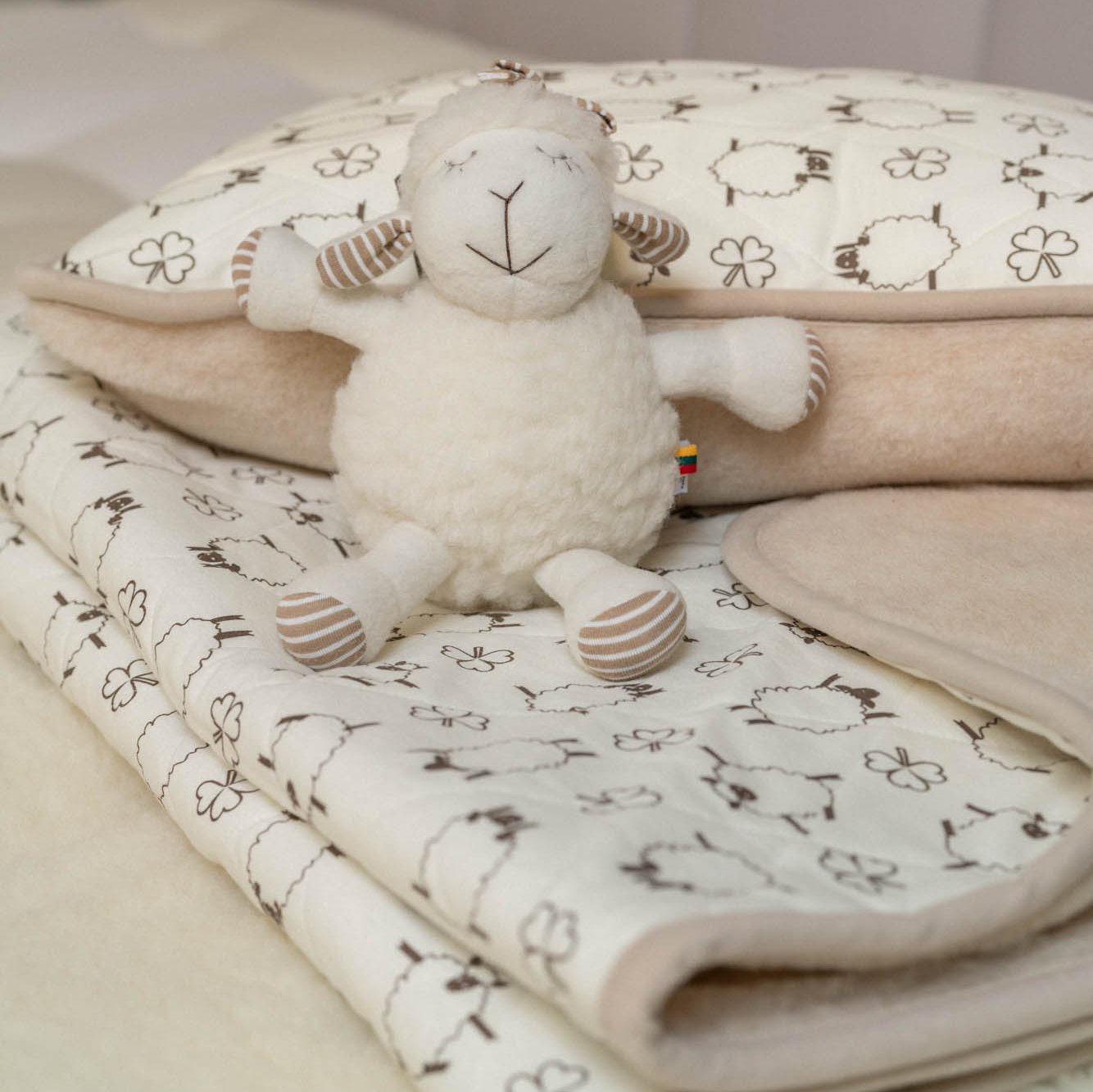 Plüschtier Schaf Kati sitzt auf Moka Kinder Wollflor Decke