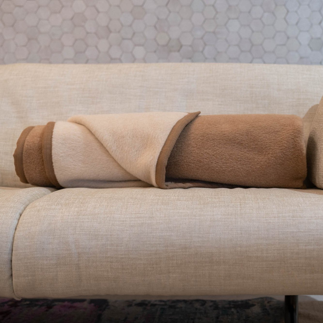 Lima Star Alpakadecke in creme/kamel auf dem Sofa
