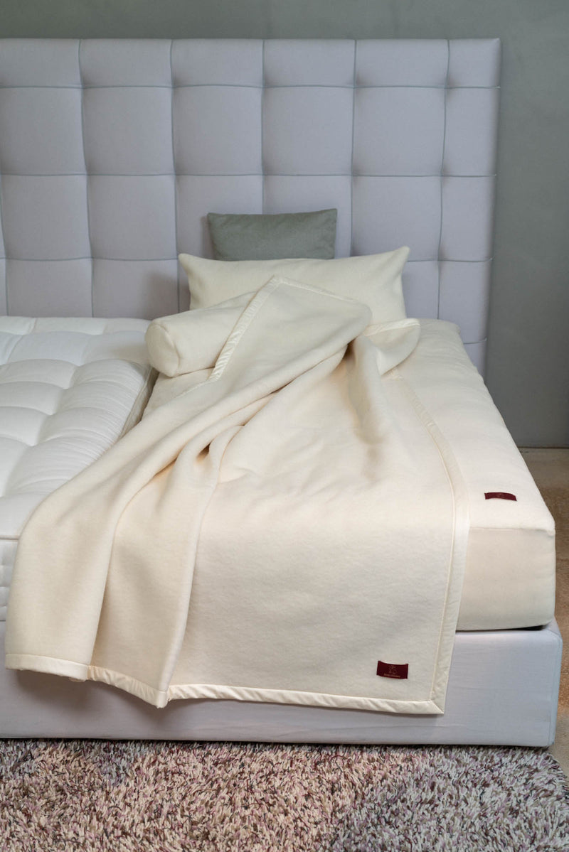 Oberbett aus Schurwolle in naturweiß auf dem Bett