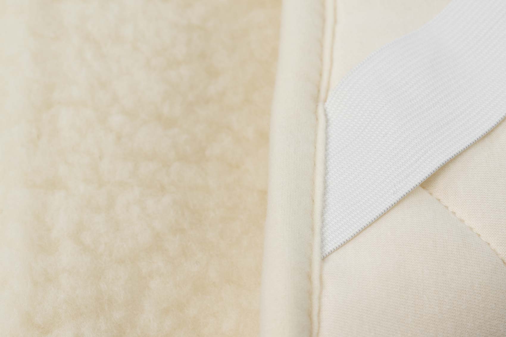 Wollflor Schurwollauflage Topper in naturweiß mit Spanneckgummis in naturweiß